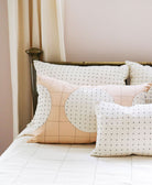 Decorative pillows with circular patterns on a bed in a bedroom setting