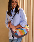 woman holding colorful checkered crescent bag over her shoulder