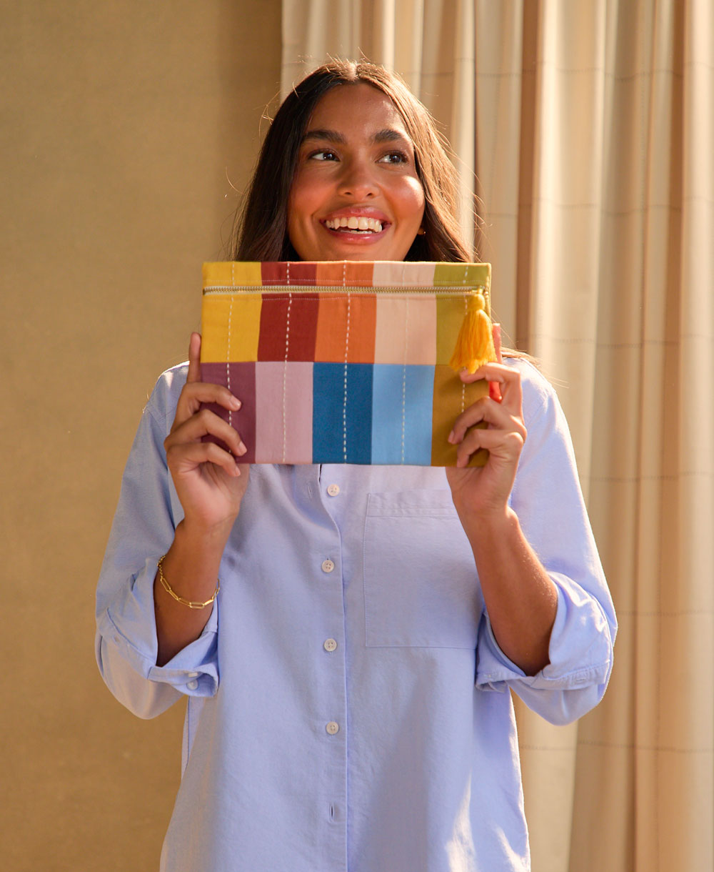 woman holding checkered canvas mosaic pouch in front of her face