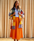 woman wearing multi check quilted cocoon jacket and orange skirt