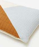 colorblock lumbar pillow with white cross-stitch embroidery and black grid-stitch embroidery for the modern sustainable home