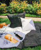 modern patchwork quilt in grass with a bottle of wine and bread on top for a picnic