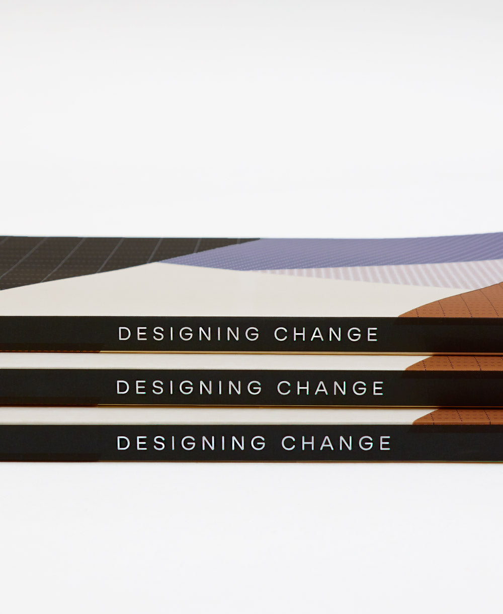 dotted grid notebook with designing change written on spine by Anchal