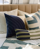 Decorative pillows on a couch with a blue, green and navy color scheme