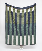 modern patchwork quilt with offset stripe pattern in cool tones of sage, spruce and navy