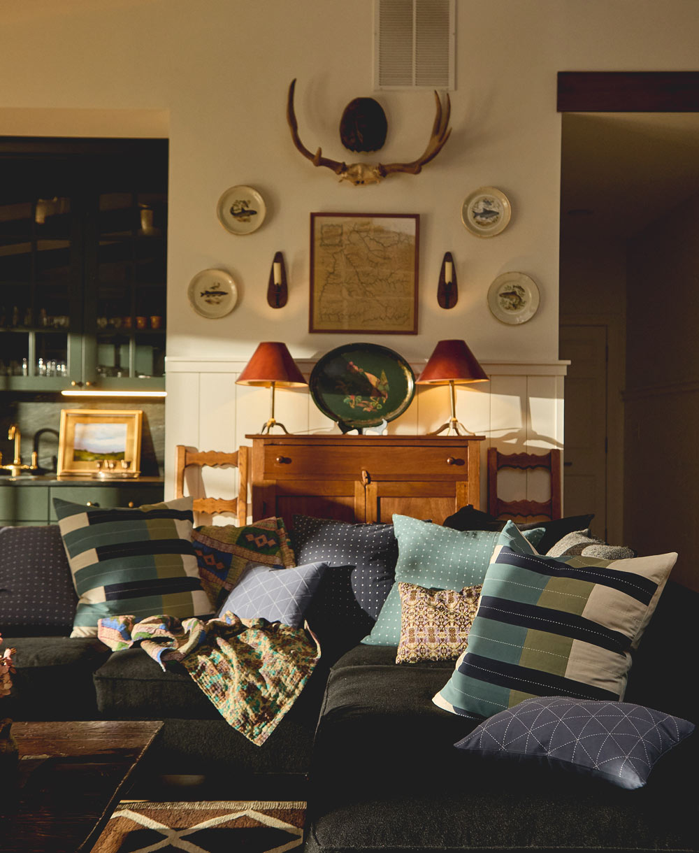 living room with dark sofa, decorative modern throw pillows, and a collage of modern rustic wall art