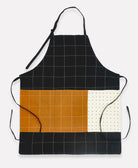 sustainably made apron with adjustable neck and waist ties in black and camel colorblock pattern