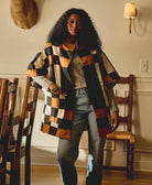 woman wearing patchwork plaid quilted jacket in camel, black and ivory