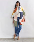 woman wearing bold quilted jacket with colorful applique abstract shapes handstitched from 100% organic cotton