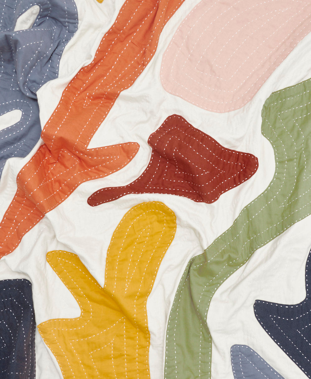 quilted throw made from 100% organic cotton with organic applique shapes