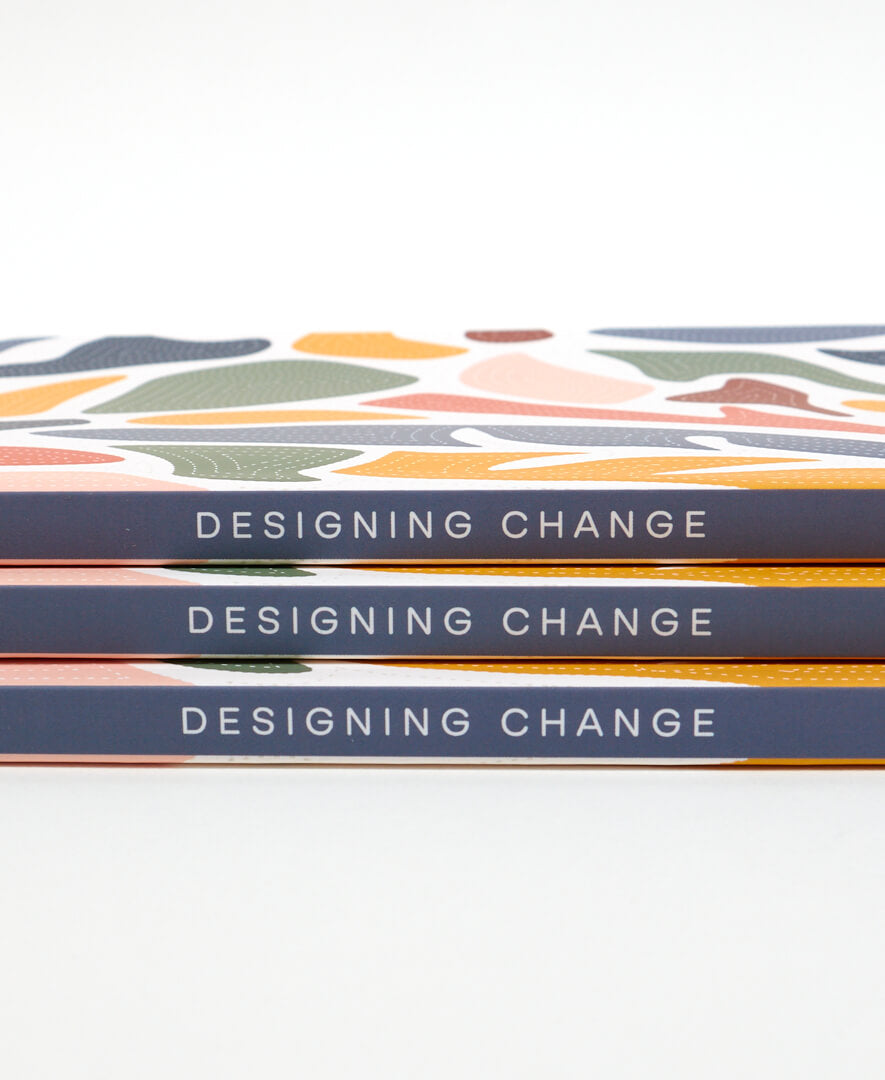 navy blue spine on grid dot notebook that says designing change