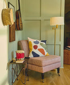 unique modern throw pillow in pink upholstered chair in mint green room