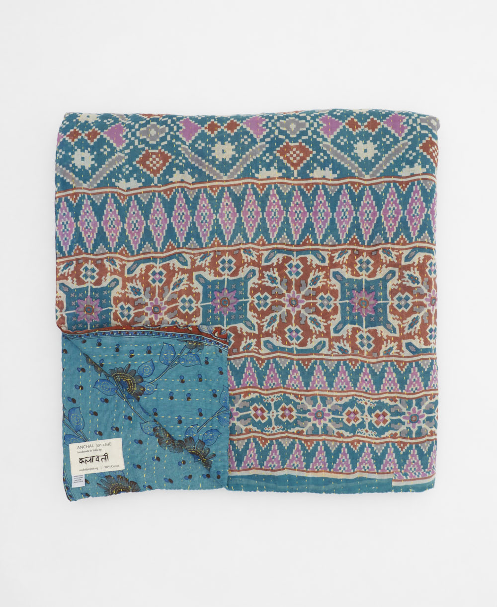 ethically made queen kantha quilt in olympic blue with a bold pink and yellow floral pattern made by Anchal artisans