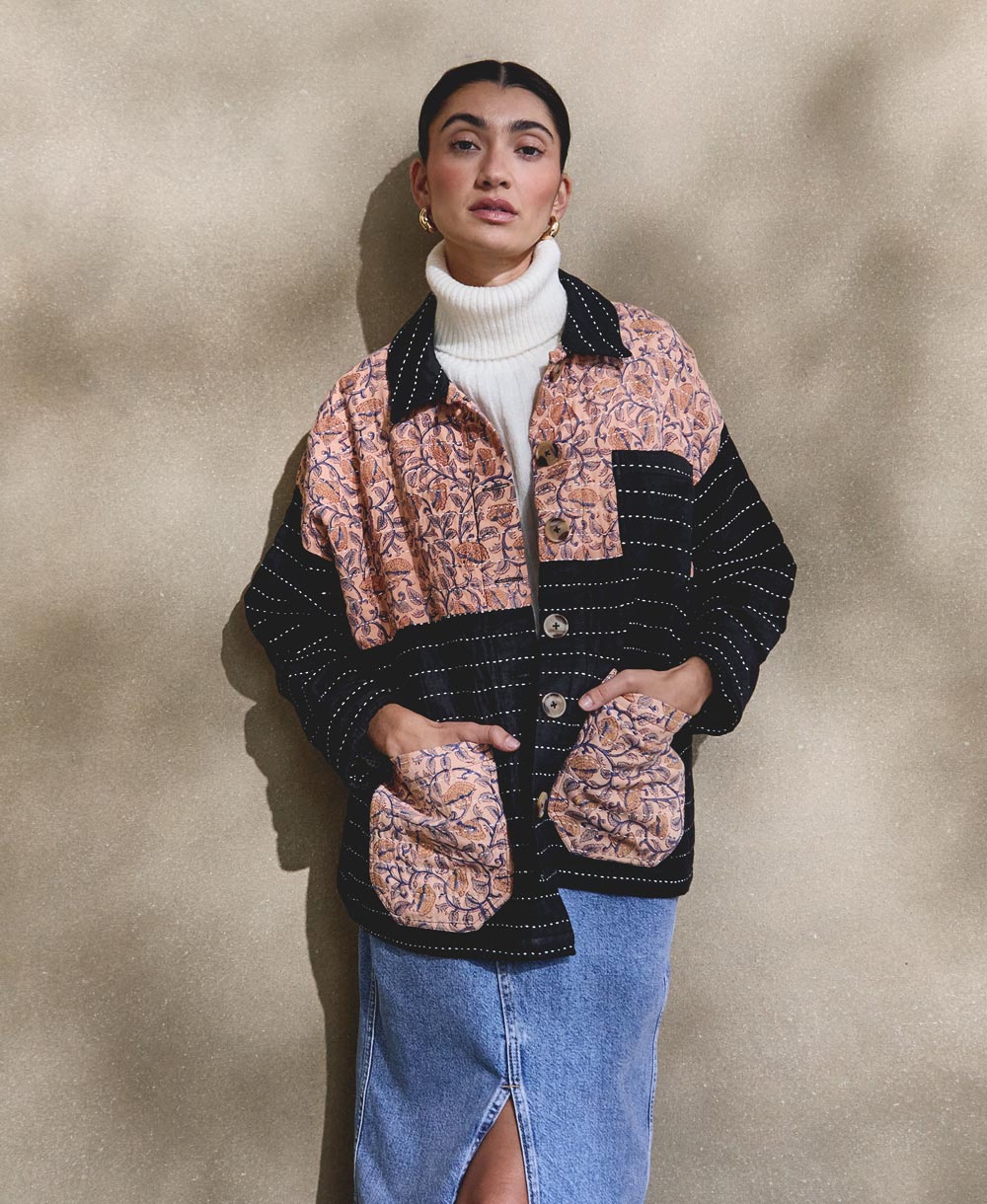 woman wearing white turtleneck sweater with black quilted chore jacket with peach floral vintage patchwork