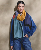 woman wearing all denim outfit with colorful cotton long scarf draped around her neck with white embroidery