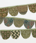Decorative fabric border with green and brown patterns on a white background