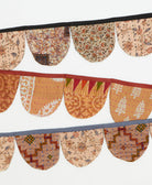 Decorative fabric bunting with intricate patterns on a white background