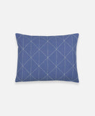 slate blue small pillow with white geometric embroidery forming a graph pattern