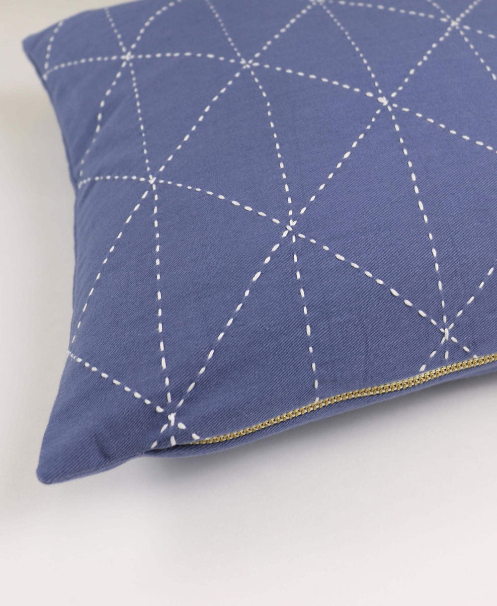 light blue small pillow with white embroidery and white geometric stitching