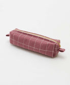 A mauve purple canvas pencil case with a white grid pattern and gold zipper, shown on a clean white background.