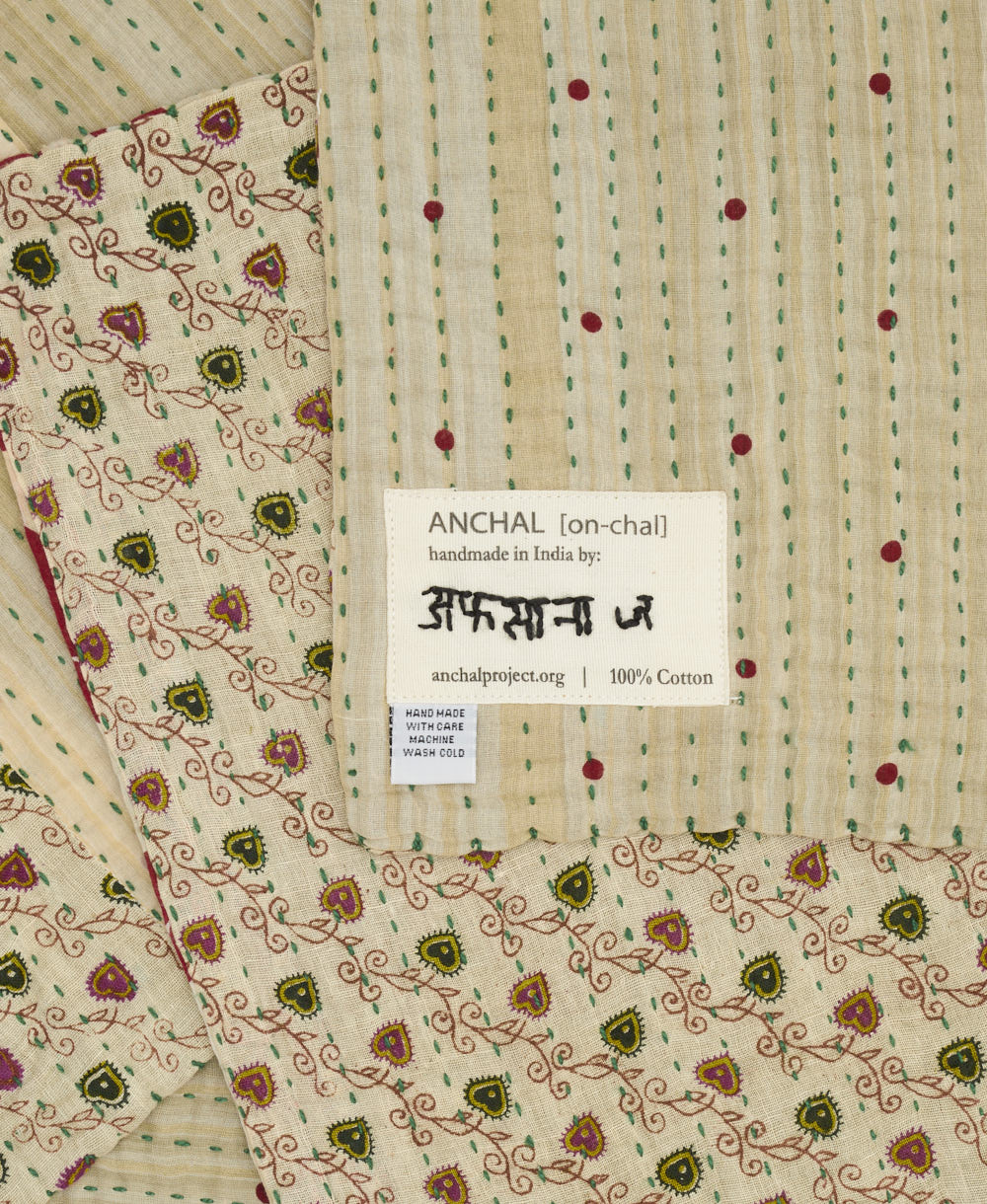 small kantha blanket in beige subtle stripe print with signature of the maker on the tag