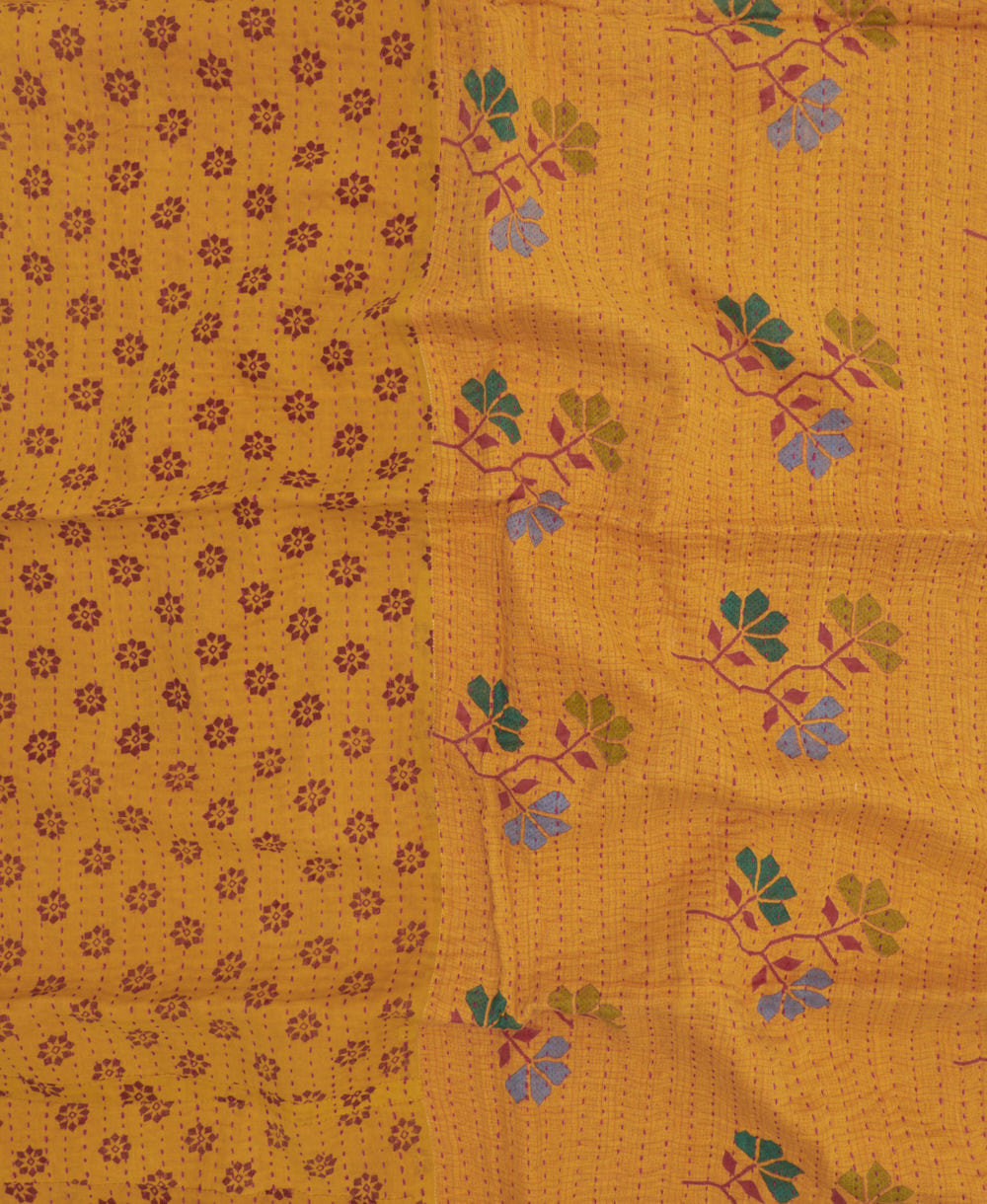 mustard yellow kantha blanket with graphic colorful floral print and pink kantha stitching