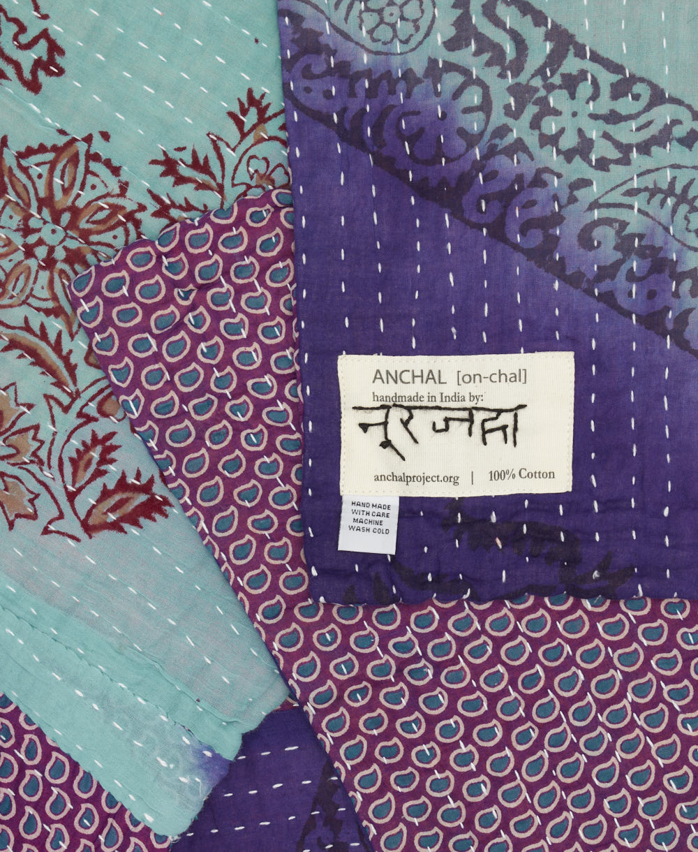 small kantha blanket in indigo purple & sky blue stripe print with signature of the maker on the tag