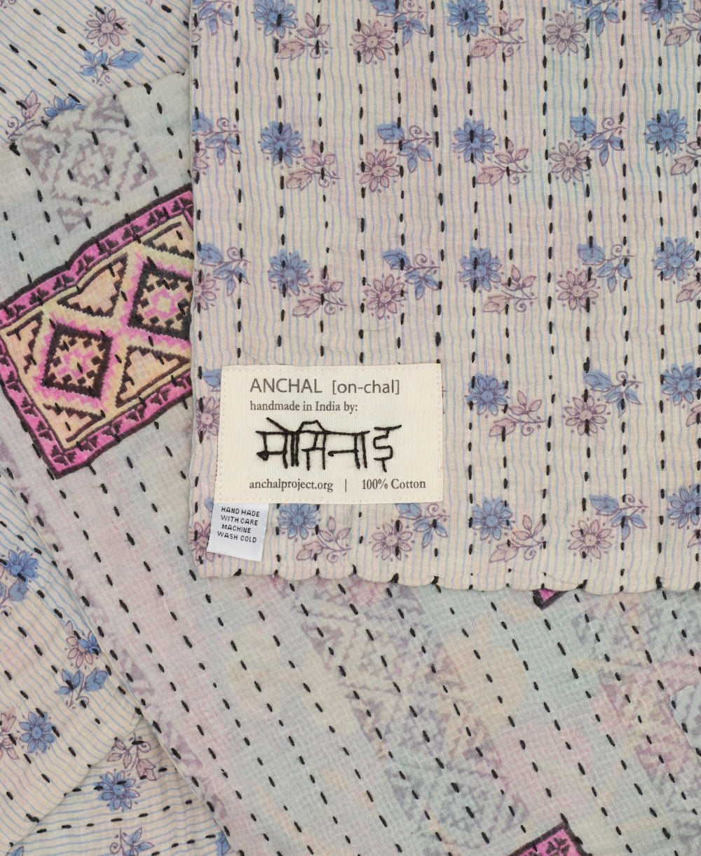 small kantha blanket in grey, pastel blue & light pink floral print with signature of the maker on the tag