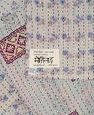 small kantha blanket in grey, pastel blue & light pink floral print with signature of the maker on the tag