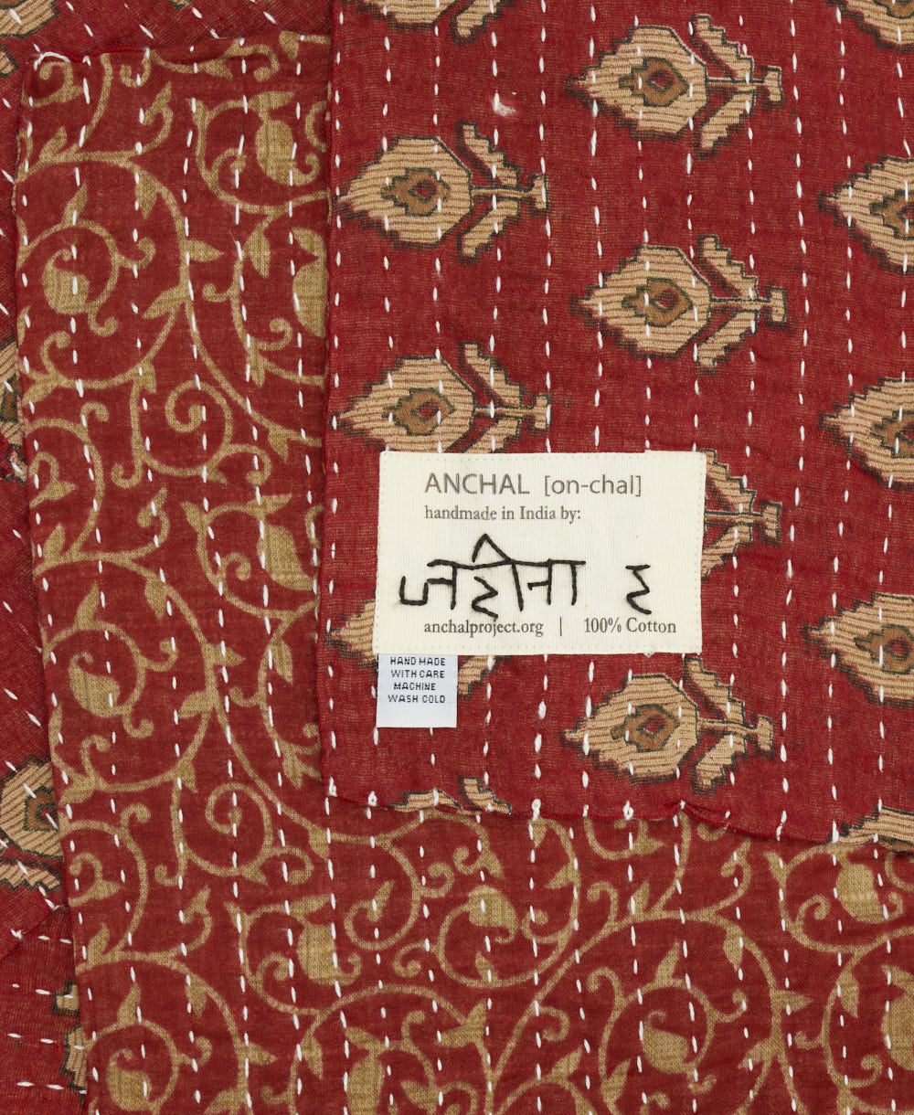 small kantha blanket with signature of the maker on the tag