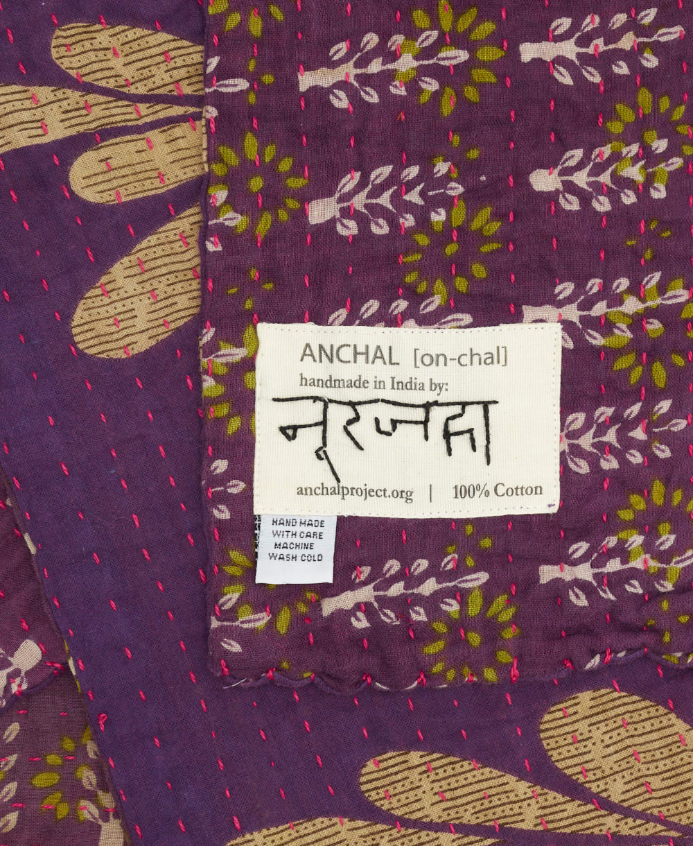 small kantha blanket with signature of the artisan maker on the tag