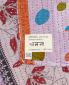small kantha blanket with signature of the artisan maker on the tag