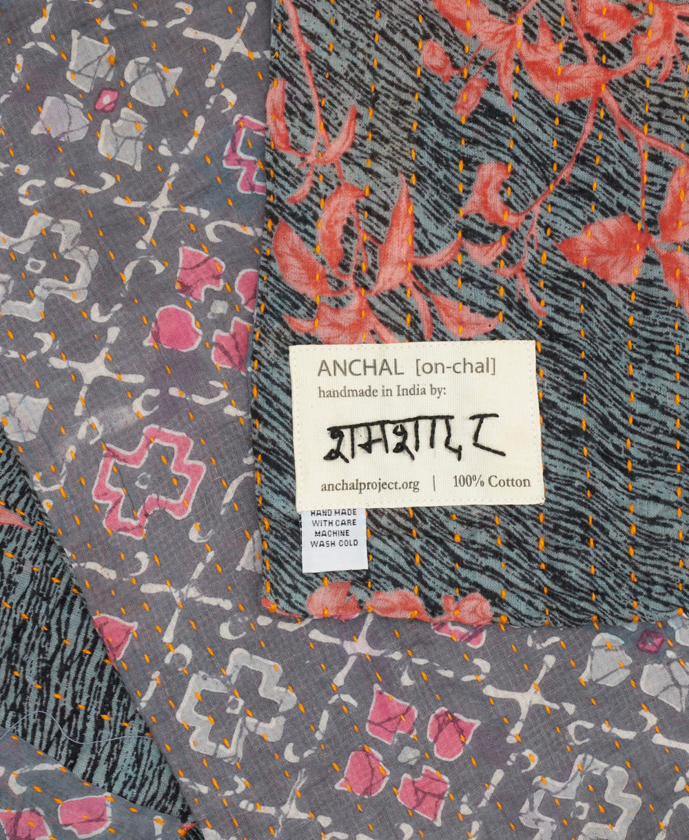 small kantha blanket with signature of the artisan maker on the tag
