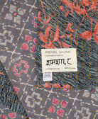 small kantha blanket with signature of the artisan maker on the tag