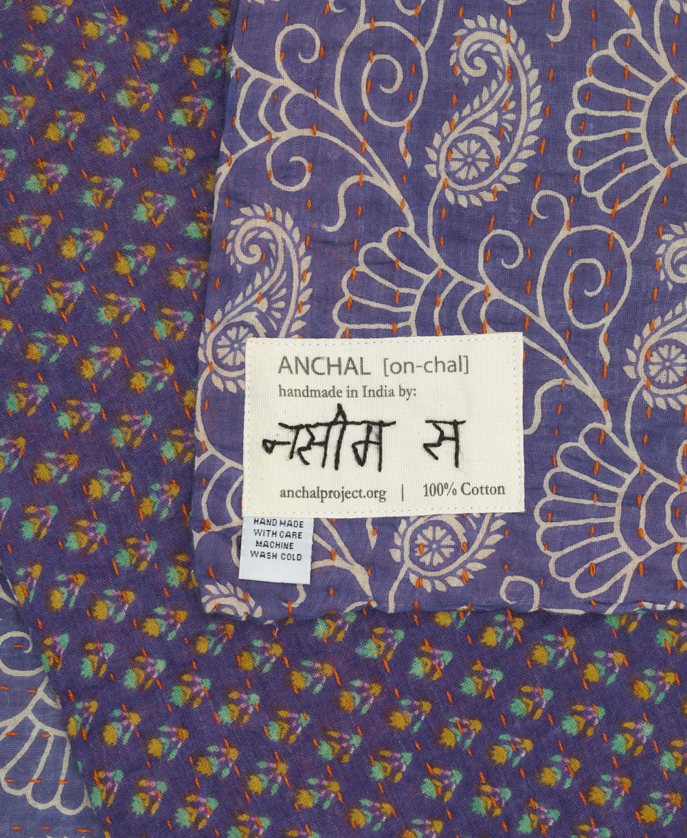 small kantha blanket with signature of the artisan maker on the tag