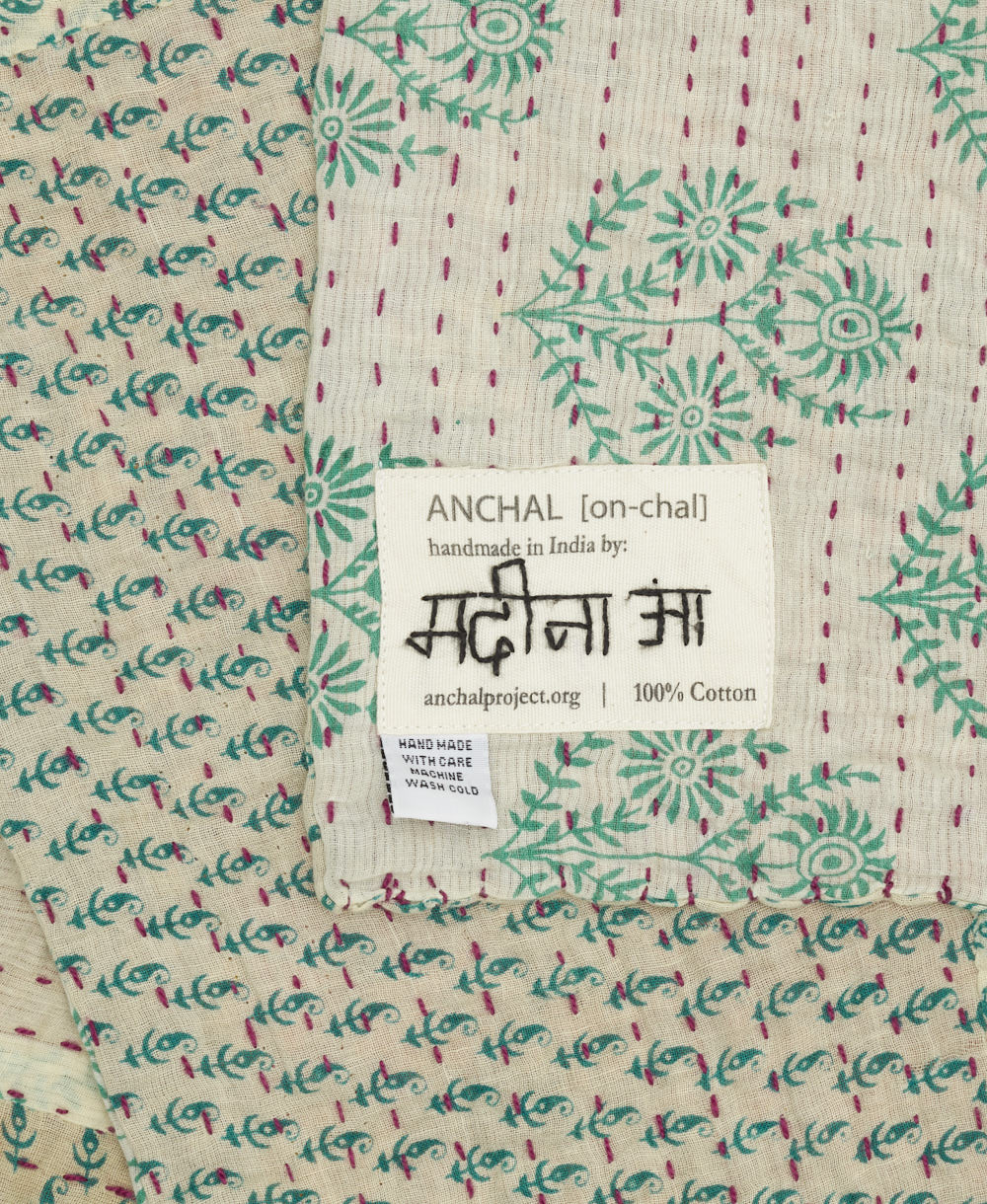 small kantha blanket with signature of the artisan maker on the tag