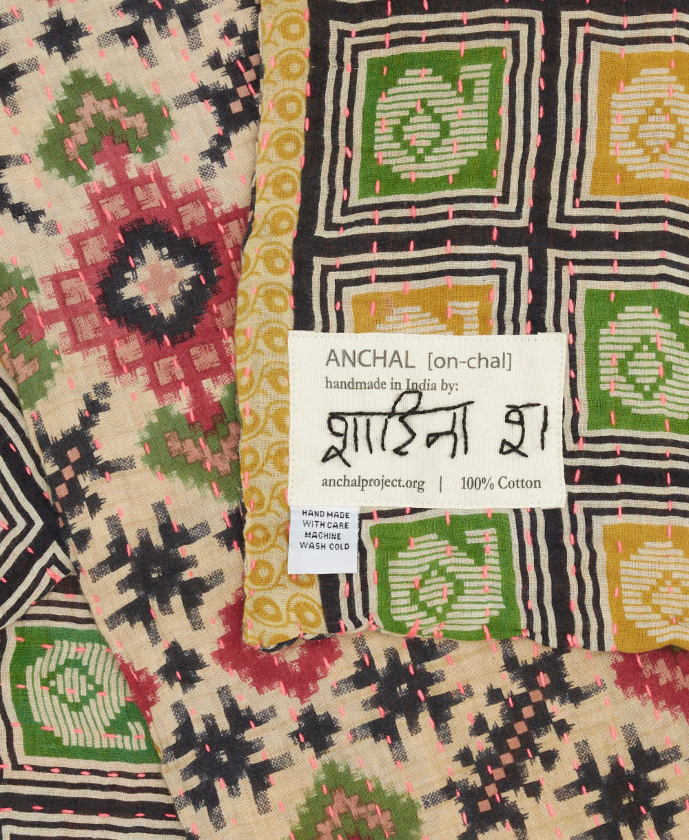 small kantha blanket with signature of the artisan maker on the tag