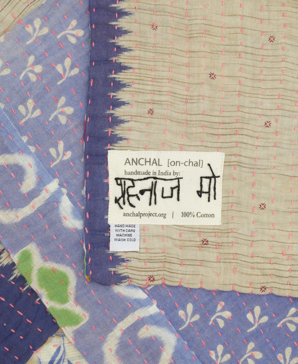 small kantha blanket with signature of the artisan maker on the tag