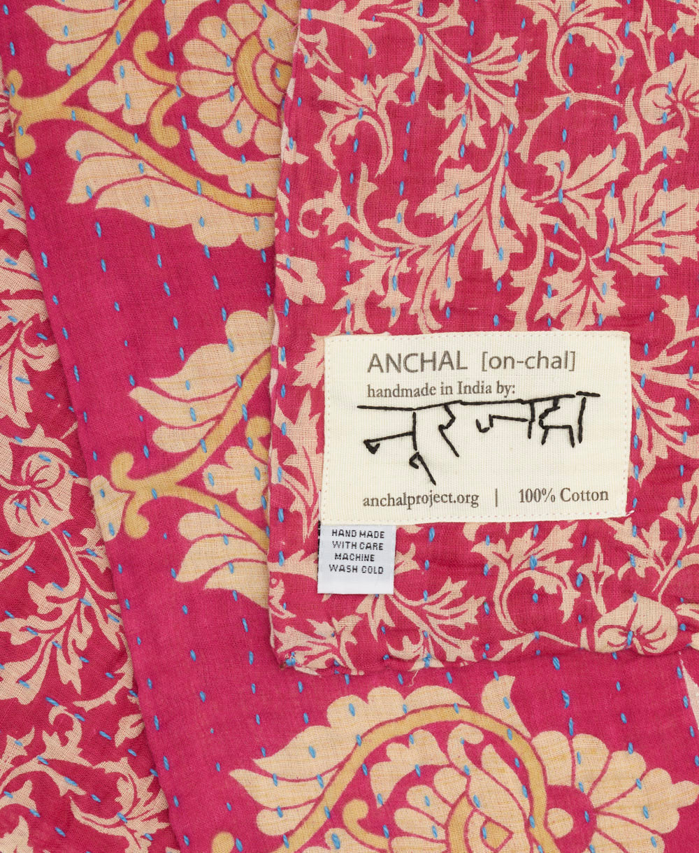 small kantha blanket with signature of the artisan maker on the tag