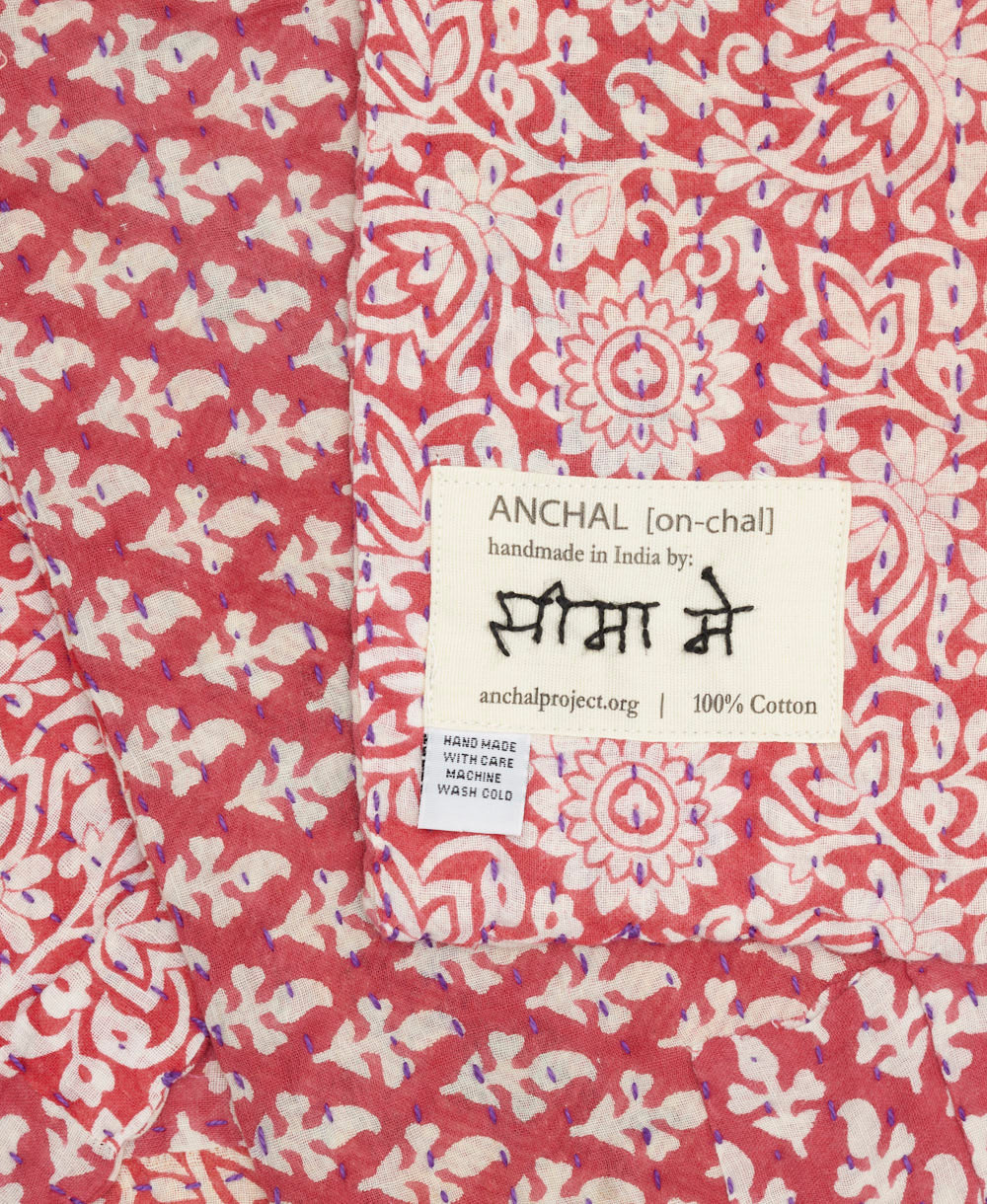 small kantha blanket with signature of the artisan maker on the tag