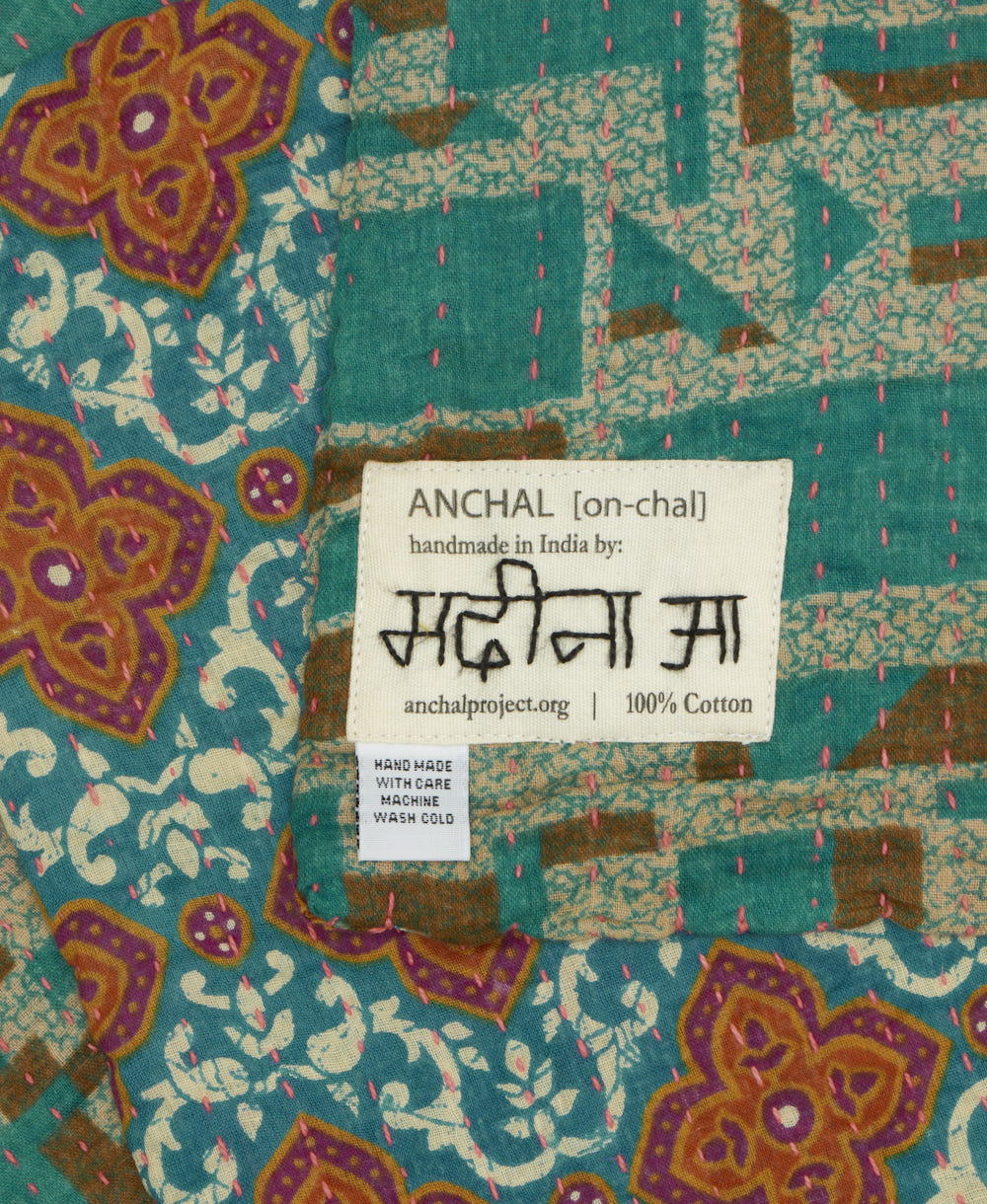 small kantha blanket with signature of the maker on the tag