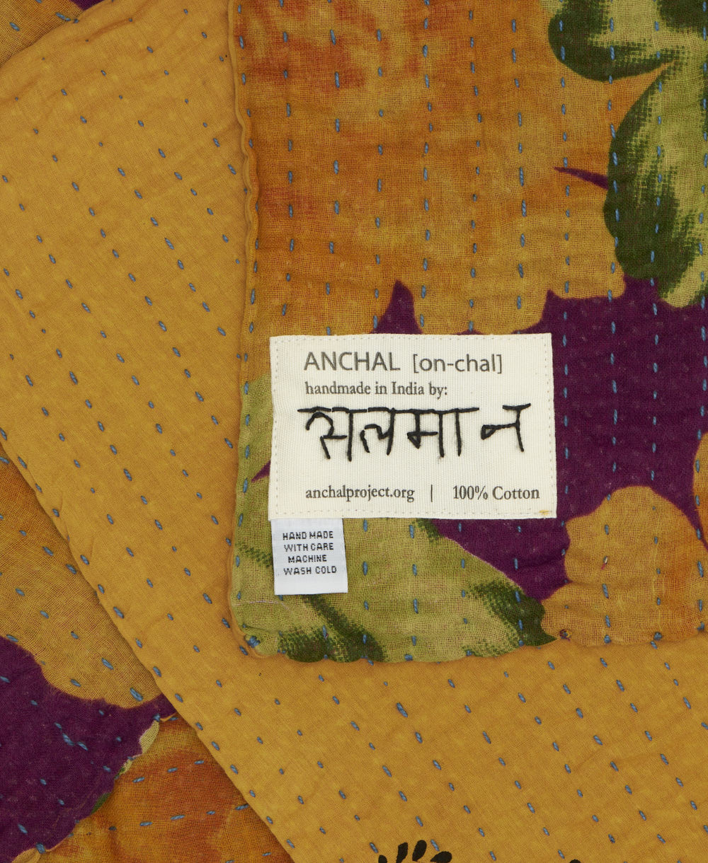 small kantha blanket with signature of the maker on the tag