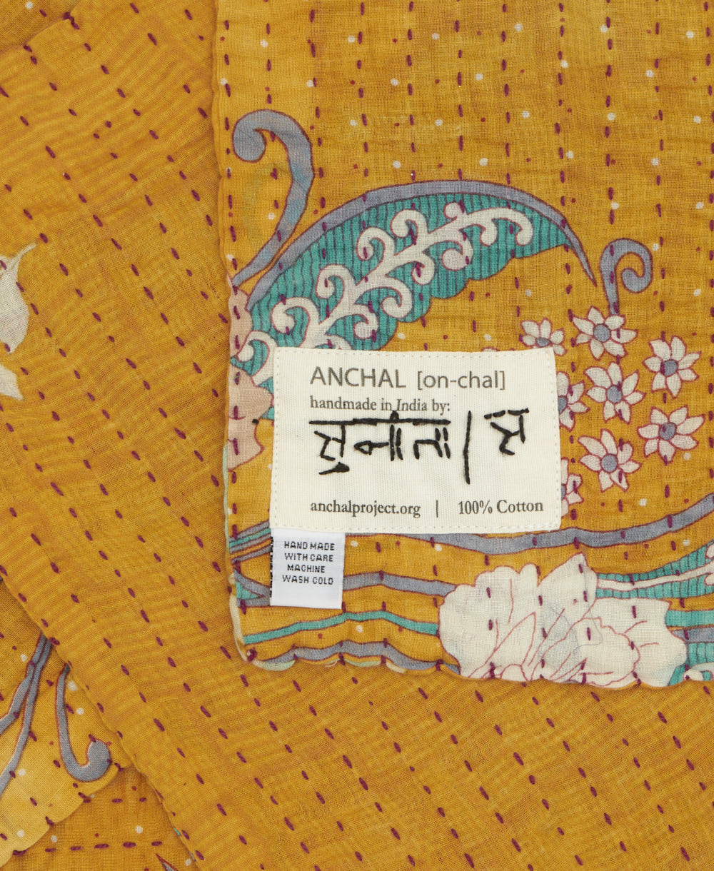 small kantha blanket with signature of the maker on the tag