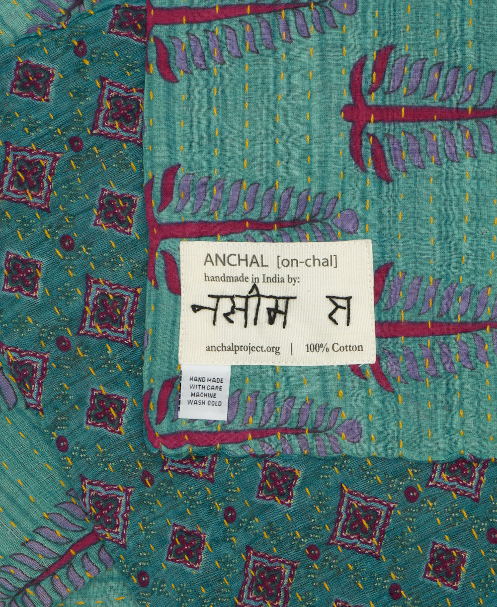 small kantha blanket with signature of the maker on the tag