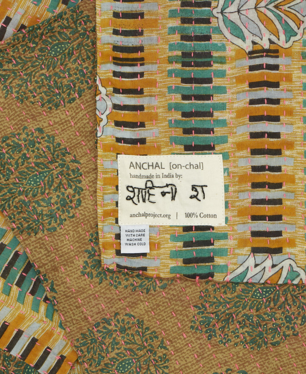 small kantha blanket with signature of the maker on the tag