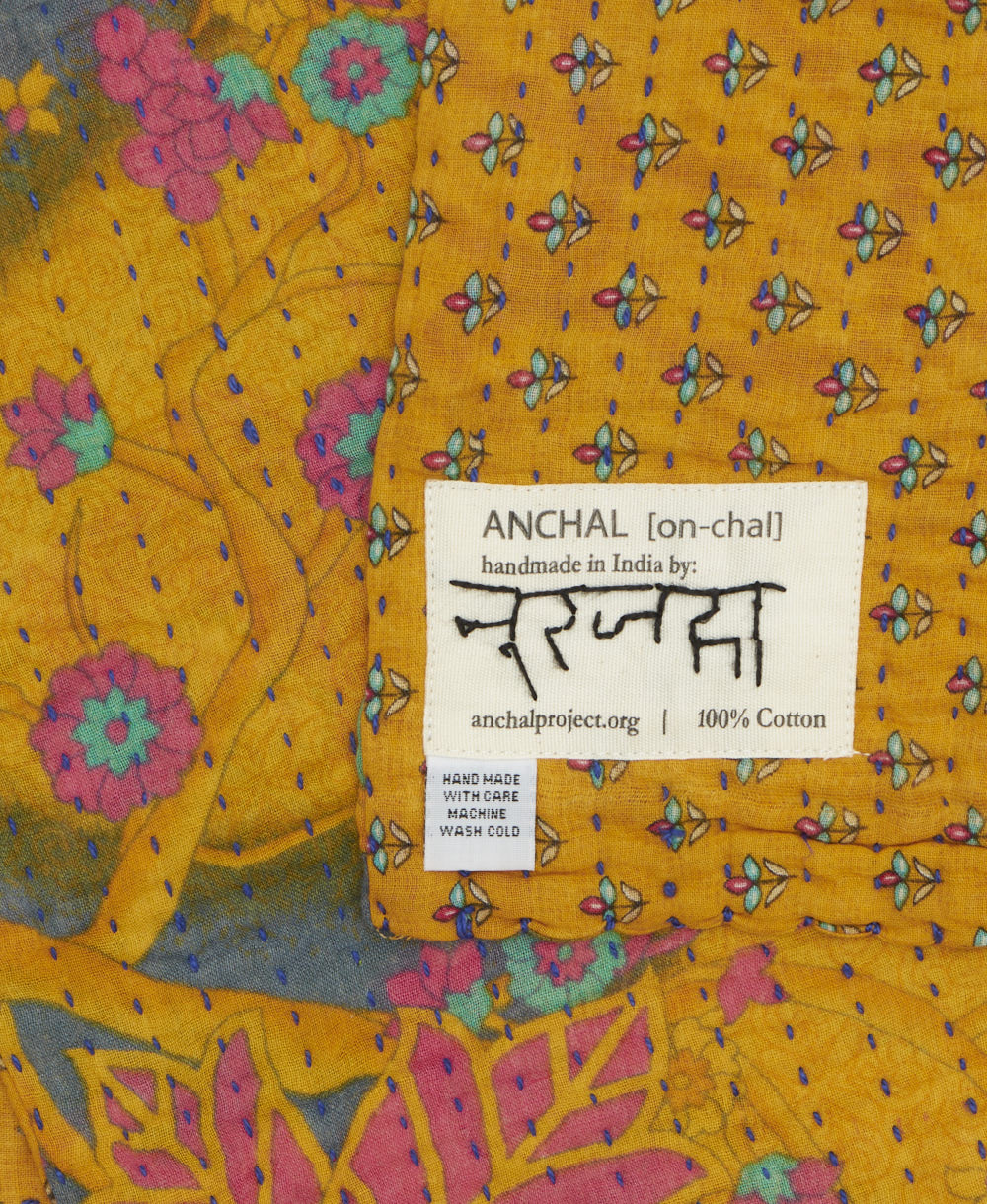 small kantha blanket with signature of the maker on the tag