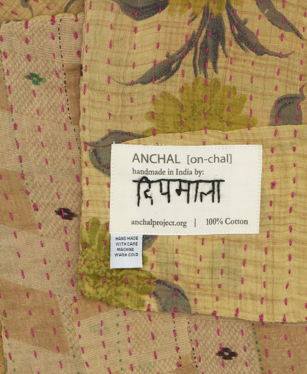 small kantha blanket with signature of the maker on the tag