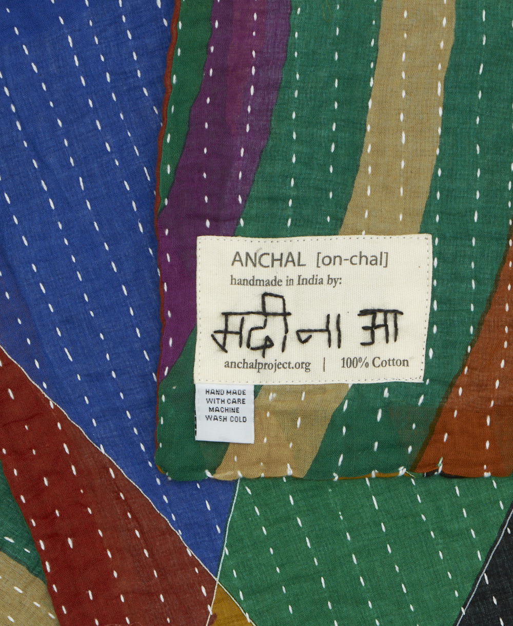 small kantha blanket with signature of the maker on the tag