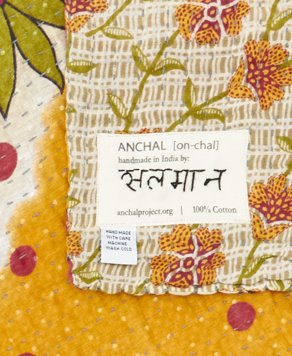 small kantha blanket with signature of the maker on the tag