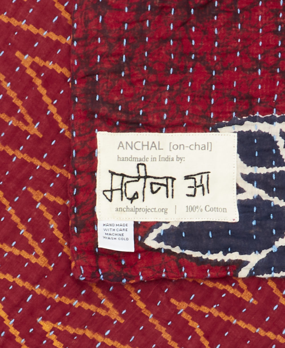 small kantha blanket with signature of the maker on the tag